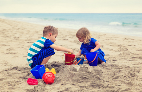 一脸不满的女孩摔倒在沙子上,把球打进网里.在沙滩排球比赛中失利.
