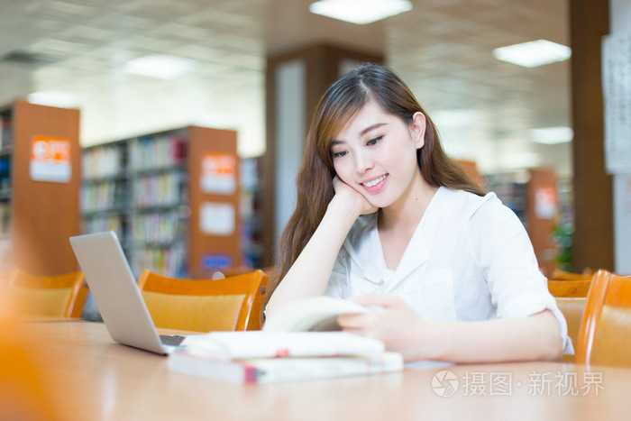 女大学生在图书馆中的笔记本电脑