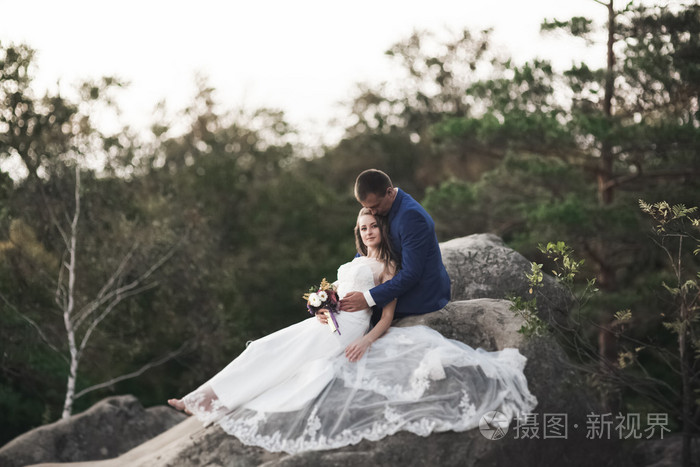 华丽的婚礼情侣接吻和拥抱附近的悬崖美景