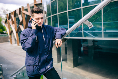 英俊的男人手机户外市街 有吸引力的年轻学生休闲蓝色上衣说话
