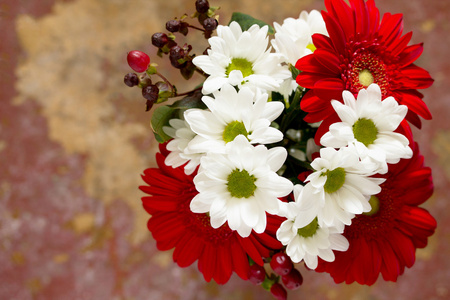 一束鲜花，上面有一朵红色的花，在一个木制的V上有一朵菊花