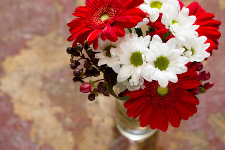 一束鲜花，上面有一朵红色的花，在一个木制的V上有一朵菊花