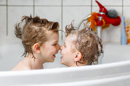 在浴缸里玩在一起的两个小男孩