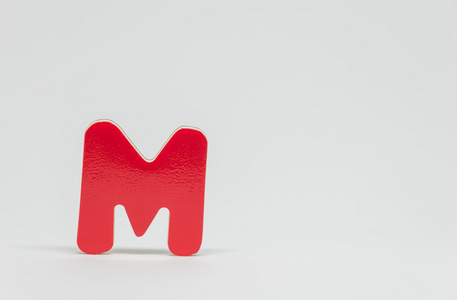 红色木制字母 M 以白色背景和选择性焦点