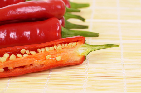 红辣椒切一半里面显示种子竹亚洲垫子上照片