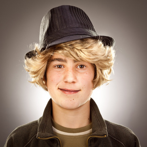 时尚复古金发男孩帽子画像在灰色的背景上