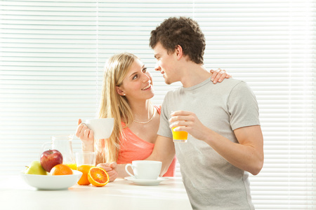 休闲对年轻夫妇有早餐咖啡和水果，百叶帘窗口