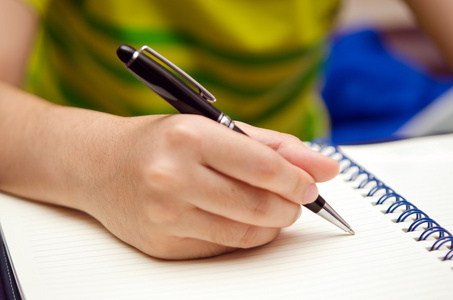 手握笔,在一本书上写照片