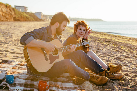夫妇在海滩上玩吉他