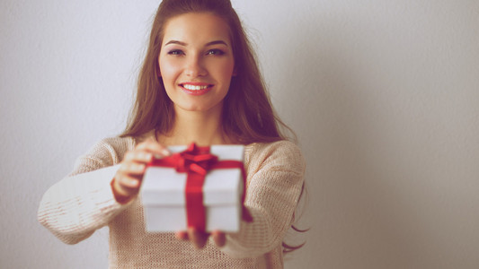 年轻女人幸福的微笑持有手中的礼品盒
