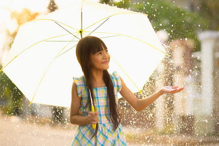 年轻的亚洲女孩在雨中