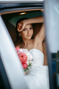 有吸引力的白种人新娘坐在车和微笑到摄像机