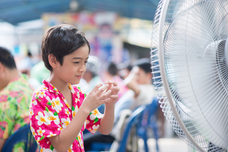 小男孩在电风扇在夏天热时间图片