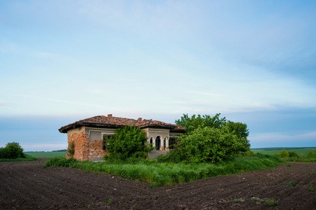 被遗弃的旧乡村房子在田野中央