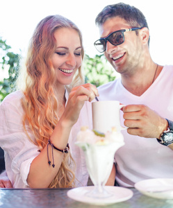 年轻夫妇享受在街边的咖啡馆的咖啡
