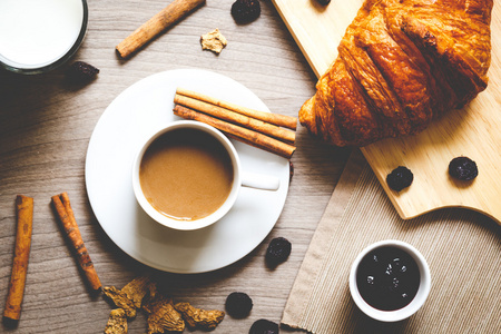 咖啡和木制的桌子上的羊角面包一起吃早餐