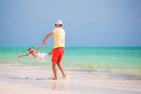 快乐的父亲和他可爱的小女儿开心的热带海滩