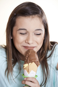 女孩的眼睛关闭享受巧克力冰淇淋