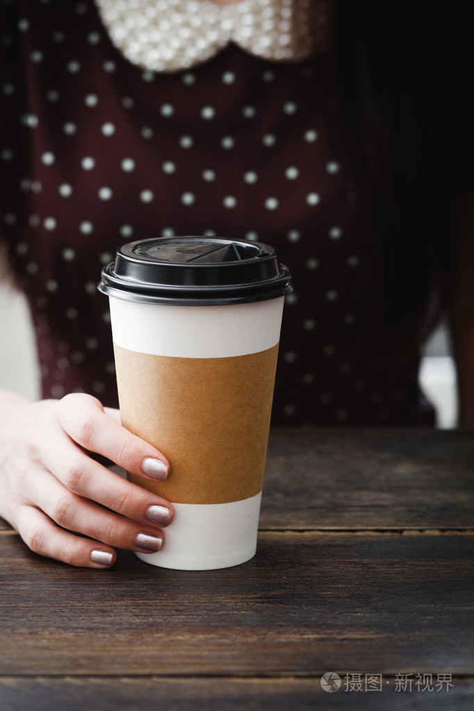 在女孩手中的咖啡纸杯