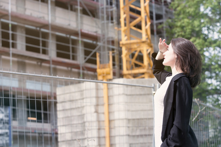 女人站在施工现场，看着建筑