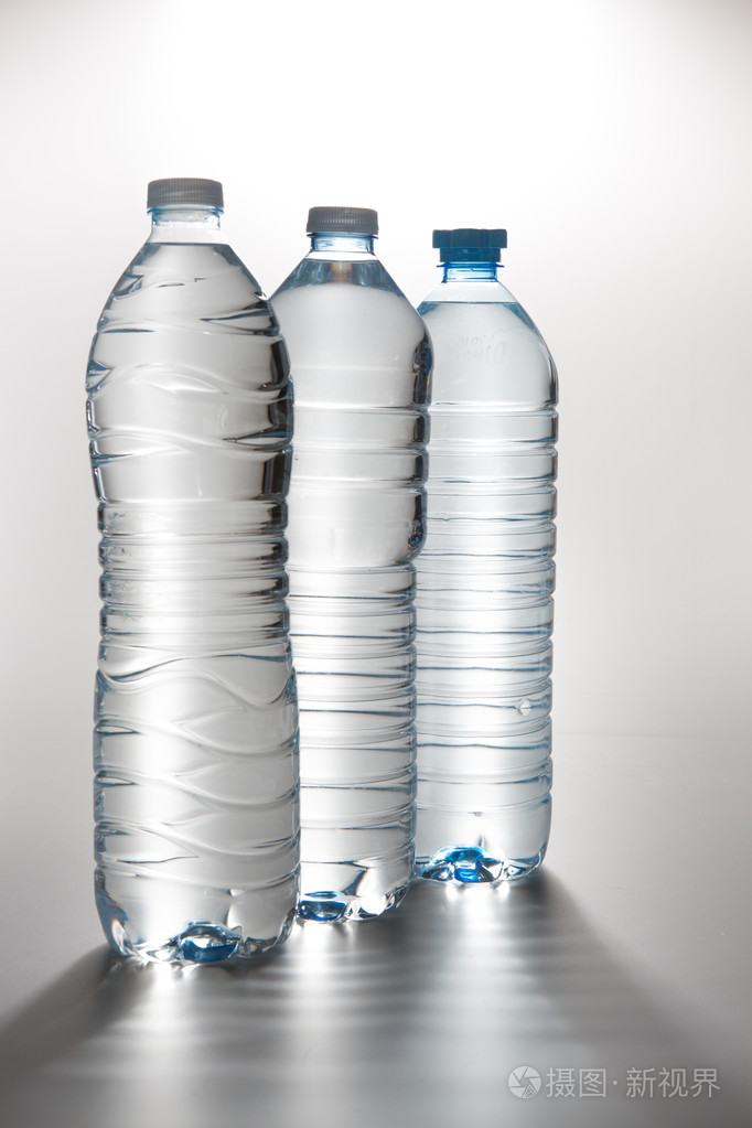 三个塑料瓶的饮用水上白色孤立