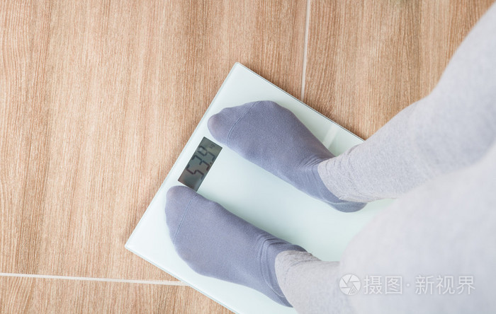 女人站在体重秤上和测量