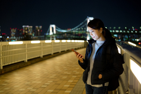 在夜间使用移动电话的女人