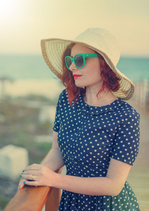 红头发的女孩，戴着帽子，太阳镜