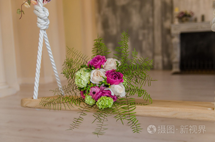 躺在秋千上的紫色和绿色的花bouqet
