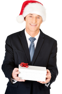一个男人穿着圣诞老人的帽子，拿着礼物的肖像
