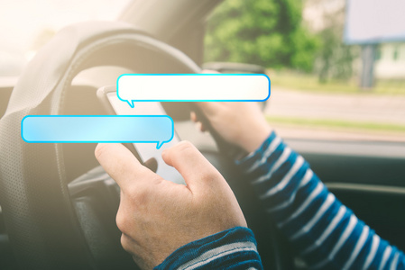 女性在带泡泡的智能手机上驾驶汽车和发短信