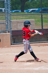 美国的青少年棒球运动员摆动的蝙蝠