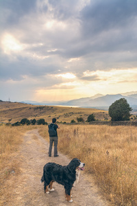 摄影师和他的狗拍照的日落