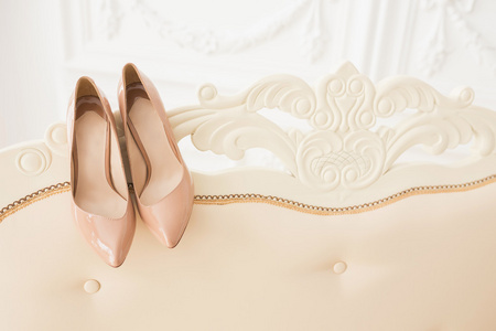 在沙发上的米色婚礼高跟鞋的特写镜头