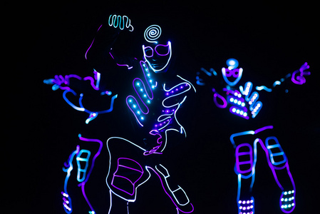 在黑暗的背景下，彩色显示的 led 套装的舞者