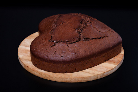 巧克力蛋糕上轻木菜板上黑色背景