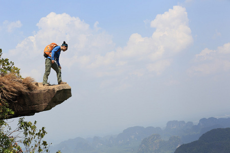 女人名徒步旅行者在悬崖上图片