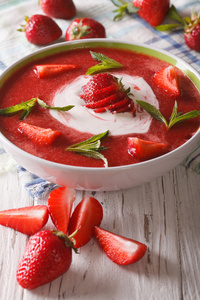 草莓的汤，用薄荷和酸奶油的特写。垂直