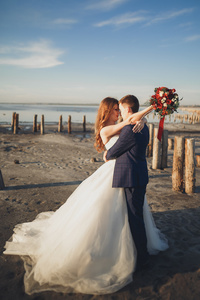 优雅时尚快乐新婚夫妇 新娘 海洋和天空的背景上的华丽新郎