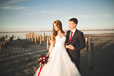 新婚夫妇，新郎，新娘花束上日落海边合影