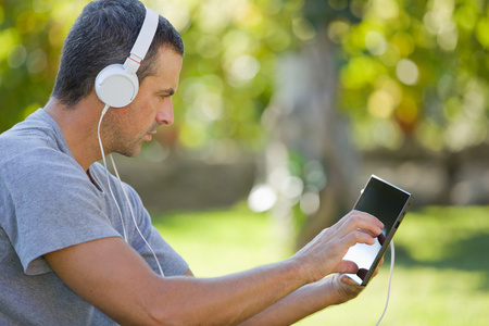 人与戴着耳机的 tablet pc 听音乐放松
