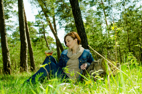 孤独的女孩享受一杯绿茶在森林里