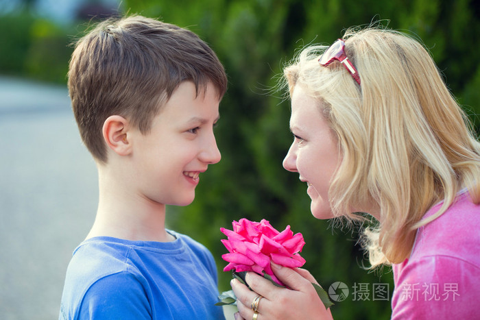 快乐的小男孩把花给妈妈