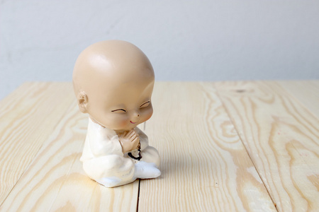 s praying, Statue neophyte on pine wood background