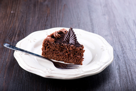 美味的巧克力蛋糕，深色木制的桌子上的盘子