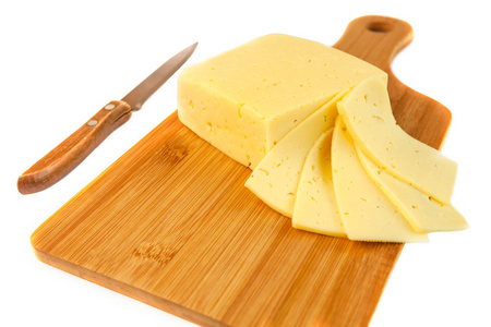 块的美味的奶酪和片上用小刀在白色背景上孤立的切菜板