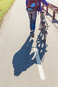 城市街道人行道路上走过的自行车的女孩