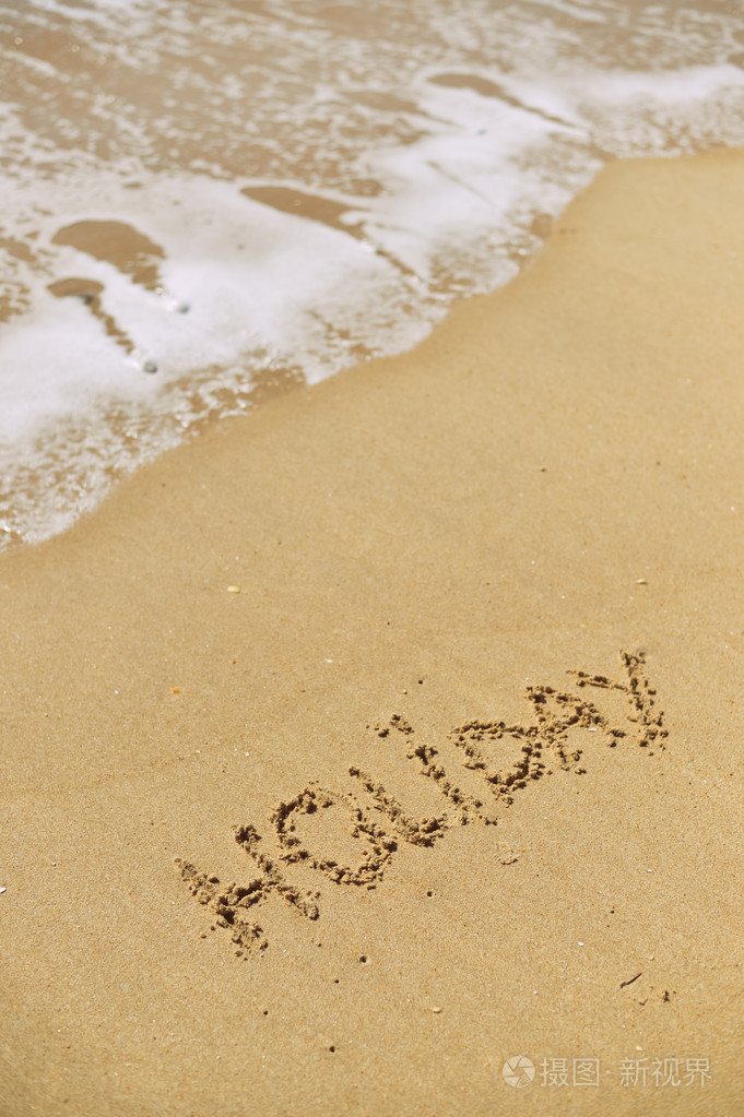 海砂海滩与反对波泡沫，太阳的光线上的题字假日的顶视图。度假概念