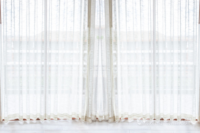 光线透过白色的窗帘在房间里