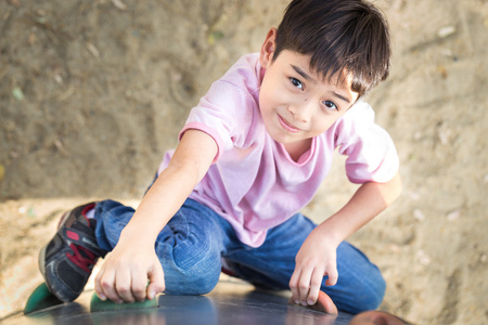 勇敢男孩爬上在操场上勇敢的小男孩照片